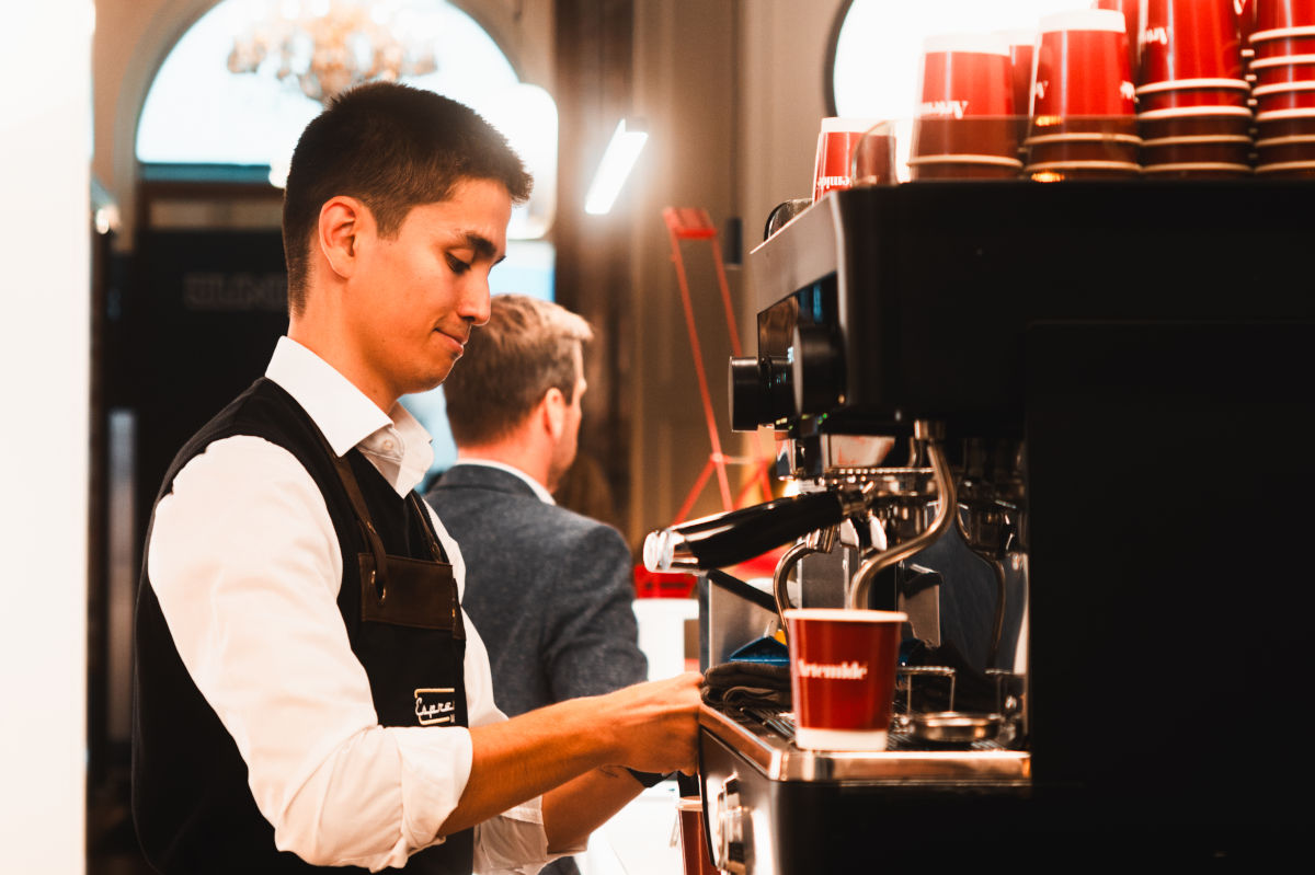 Espressomobil Barista bedient eine Kaffeemaschine